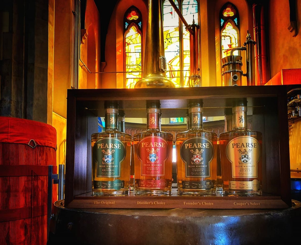 Four bottles of Pearse Lyons Irish Whiskey on whiskey barrel in Pearse Lyons Distillery