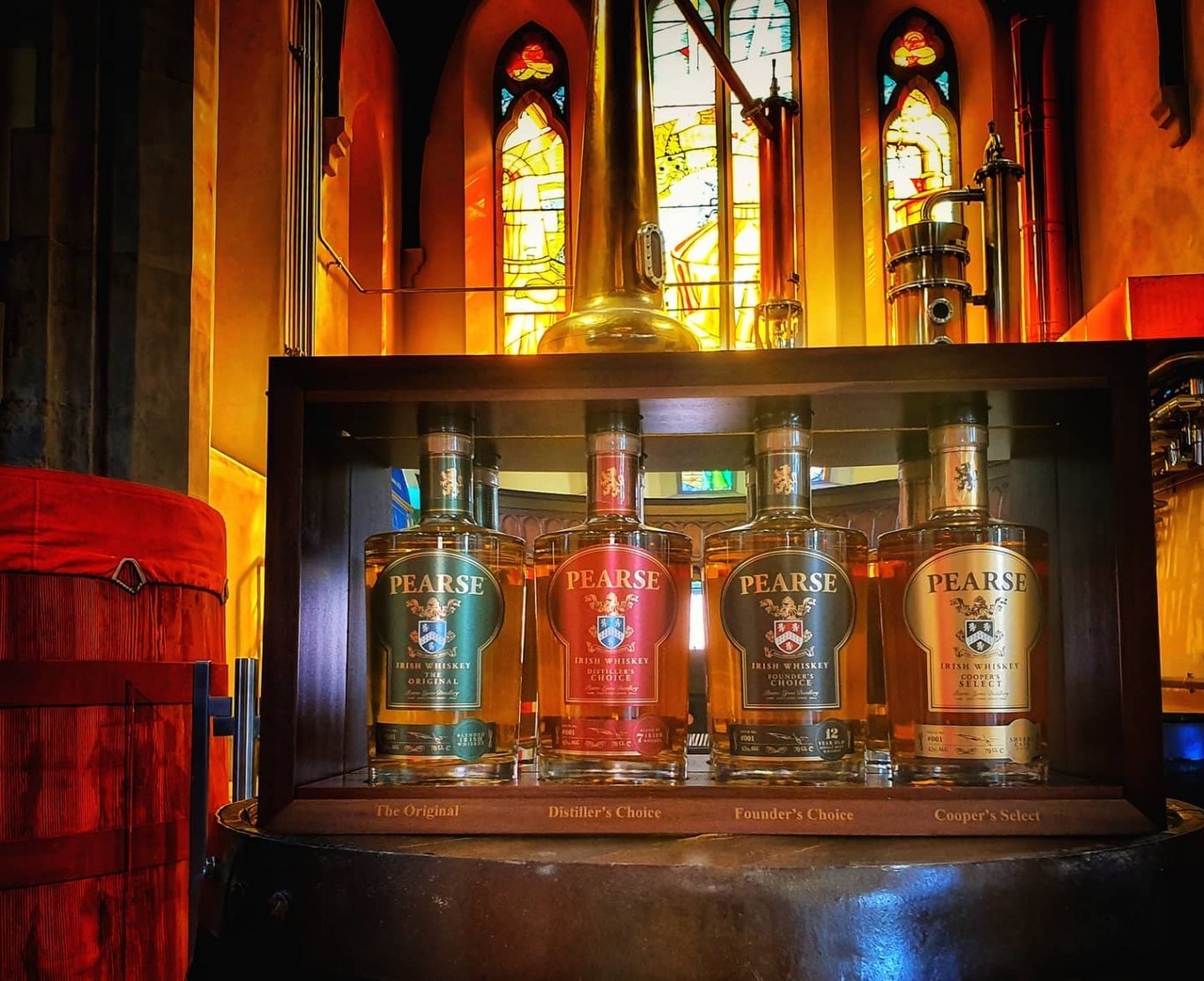 Four bottles of Pearse Lyons Irish Whiskey on whiskey barrel in Pearse Lyons Distillery