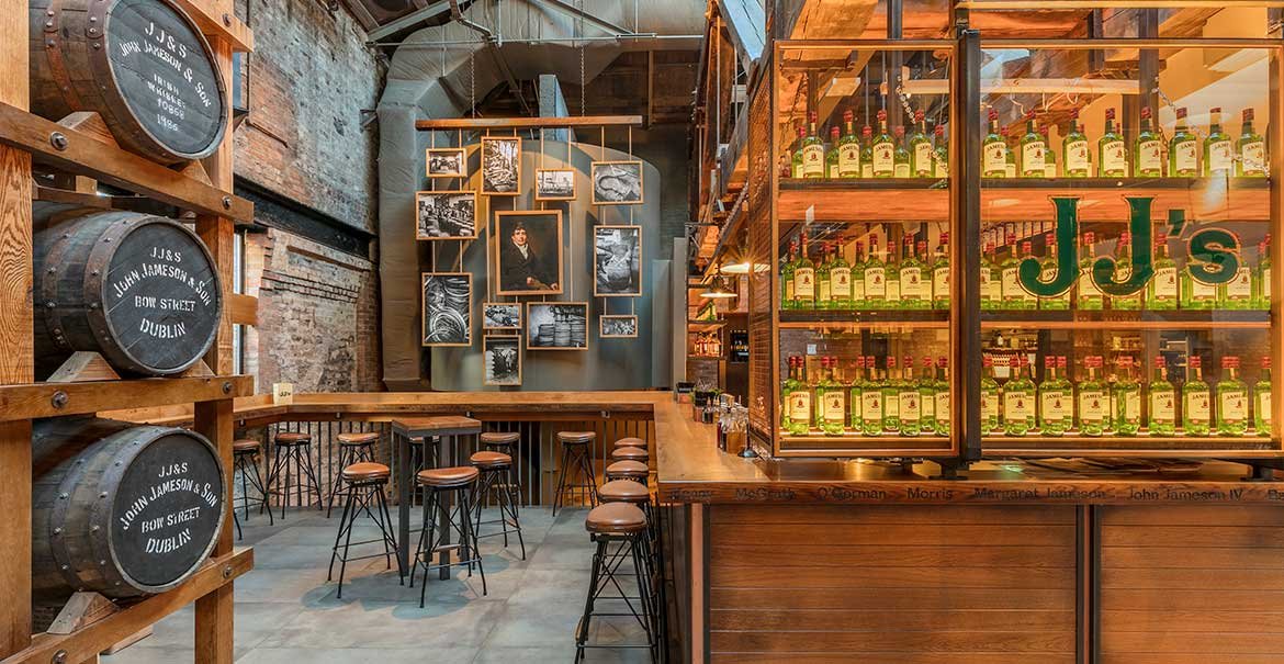 Whiskey barrels and empty bar stools at JJs bar in Jameson whiskey distillery