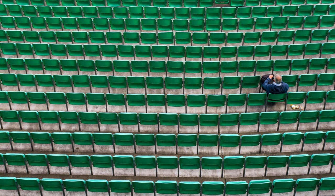 one fan sitting in stadium seating row