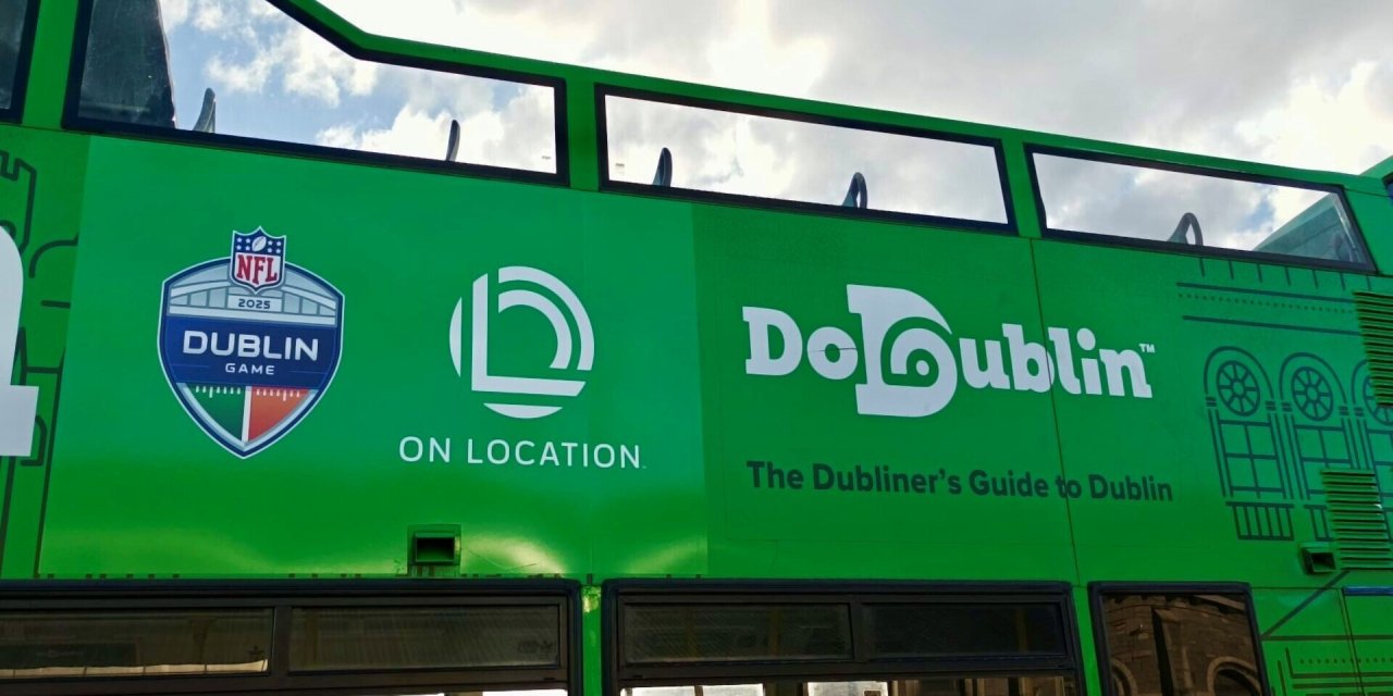 Close up of DoDublin Green Bus. NFL Branding on the side.