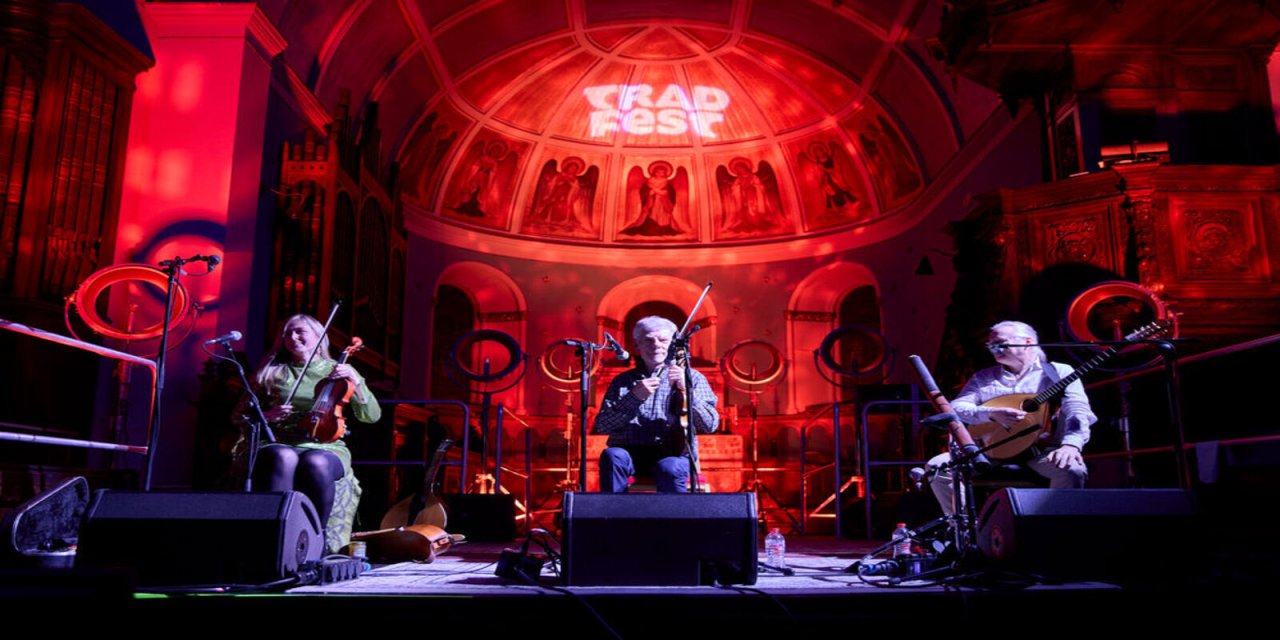 Red strobe light highlighting the three person band playing on stage