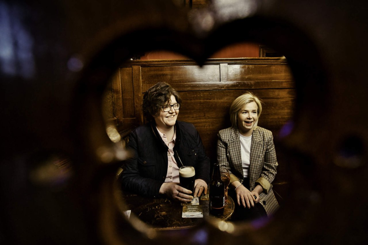 two friends enjoying a pint of guinness in a pub