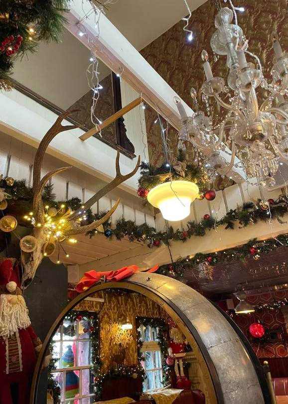 Stags head on the wall surrounded by Christmas decorations 
