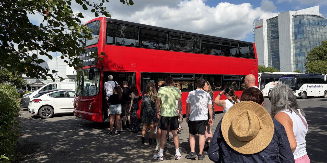 people queuing to get onto red bus