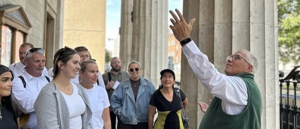 people standing beside pillars looking at guide