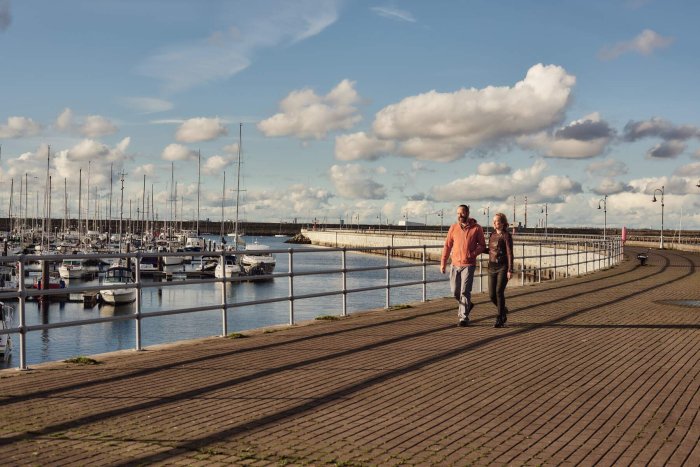 two people walking on a pier 