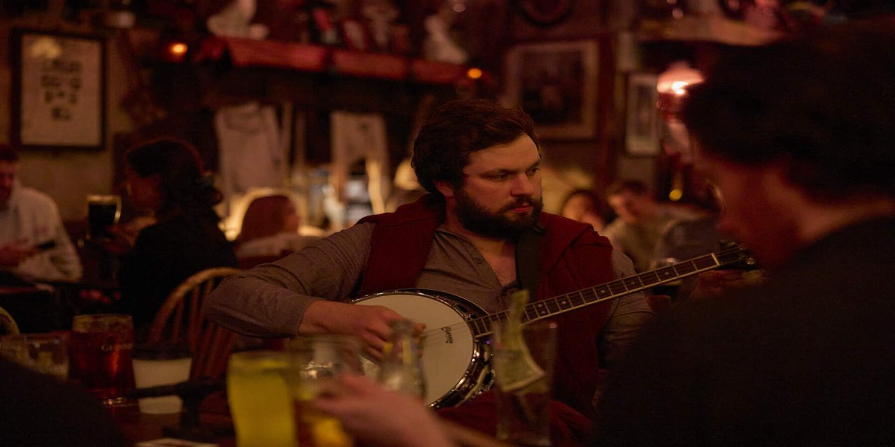 Man playing the guitar in the middle of a pub