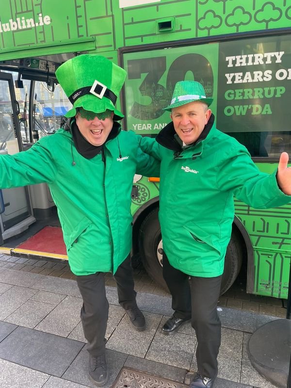 two male's wearing green hats outside the bus
