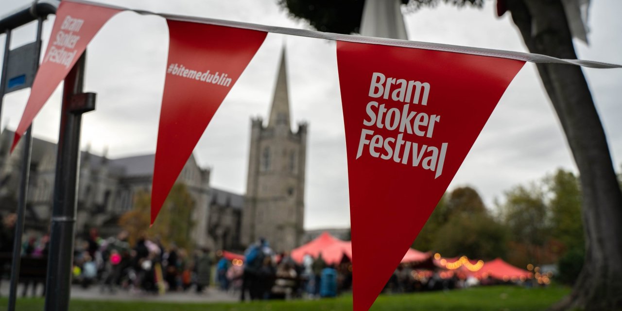 Close up image of a banner saying bram stoker festival, with church in the background 