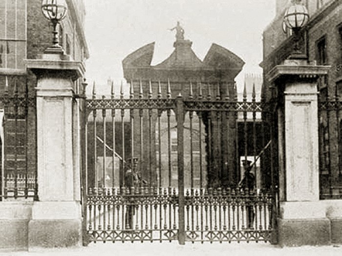 black and white photo of the gates t Dublin castle with two guards