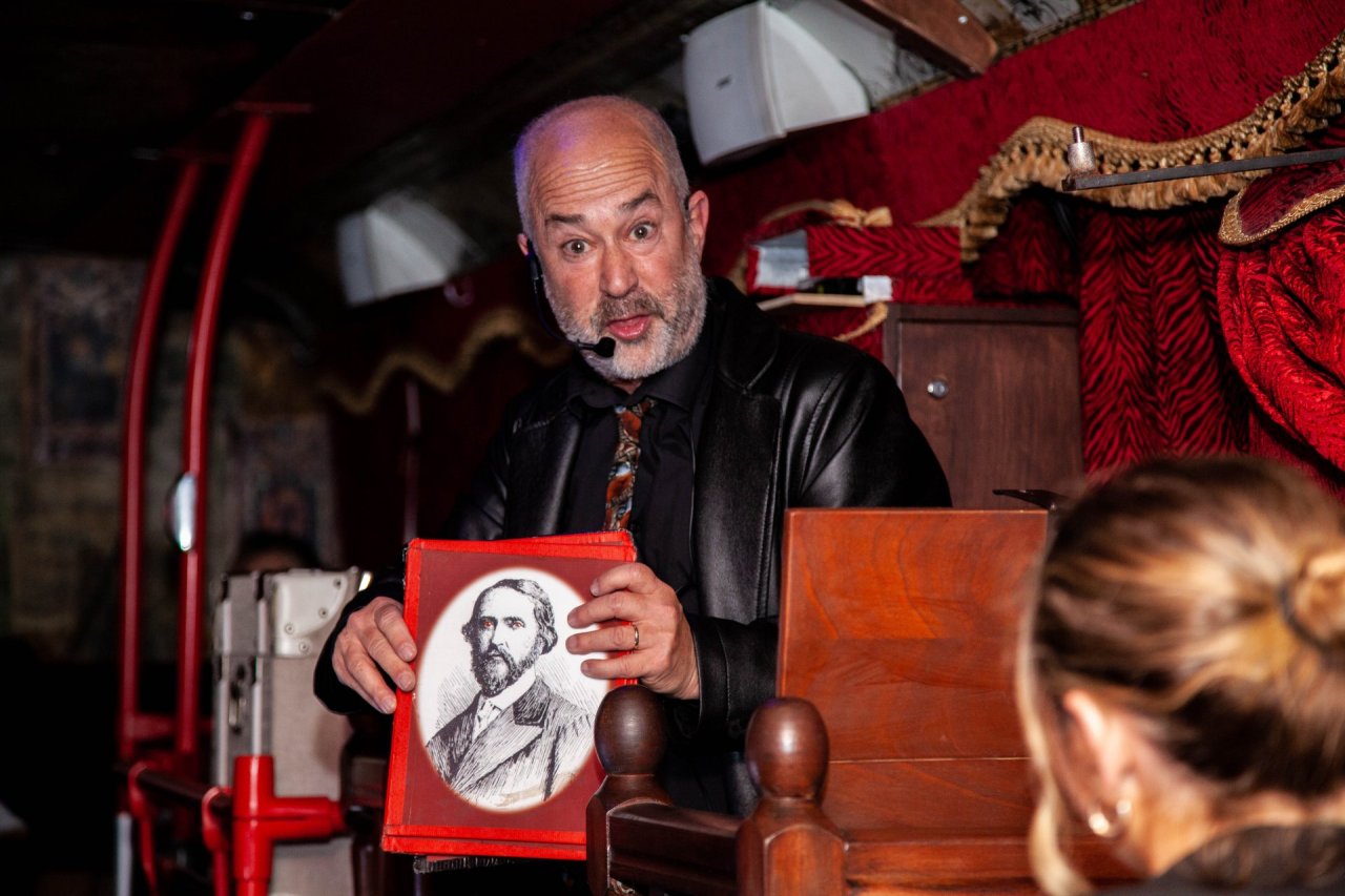 Image of man showing a historical picture to guests 