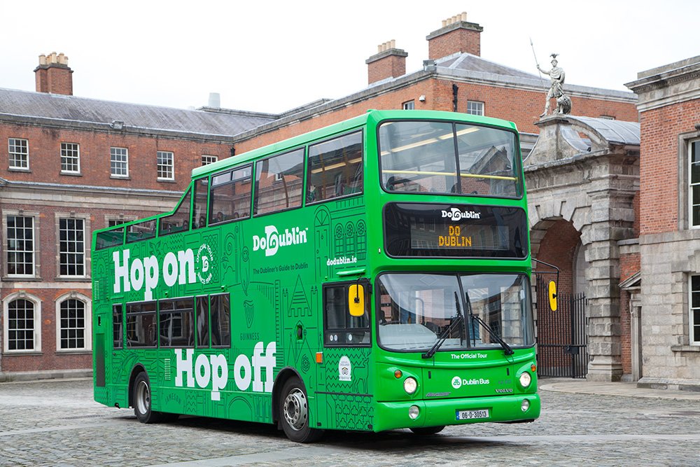 The DoDublin Green Bus tour bus outside Collins Barracks the sky is grey 