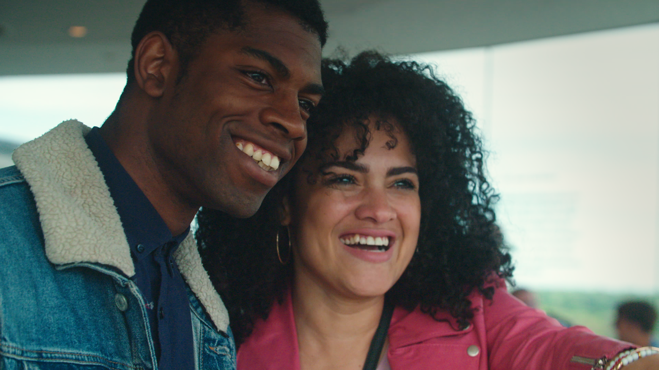 a man and a woman both smiling, not looking at camera 
