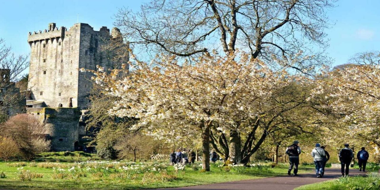 people walking through castle gardens