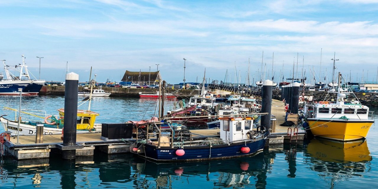 Bright blue harbour with multiple coloured boats docked