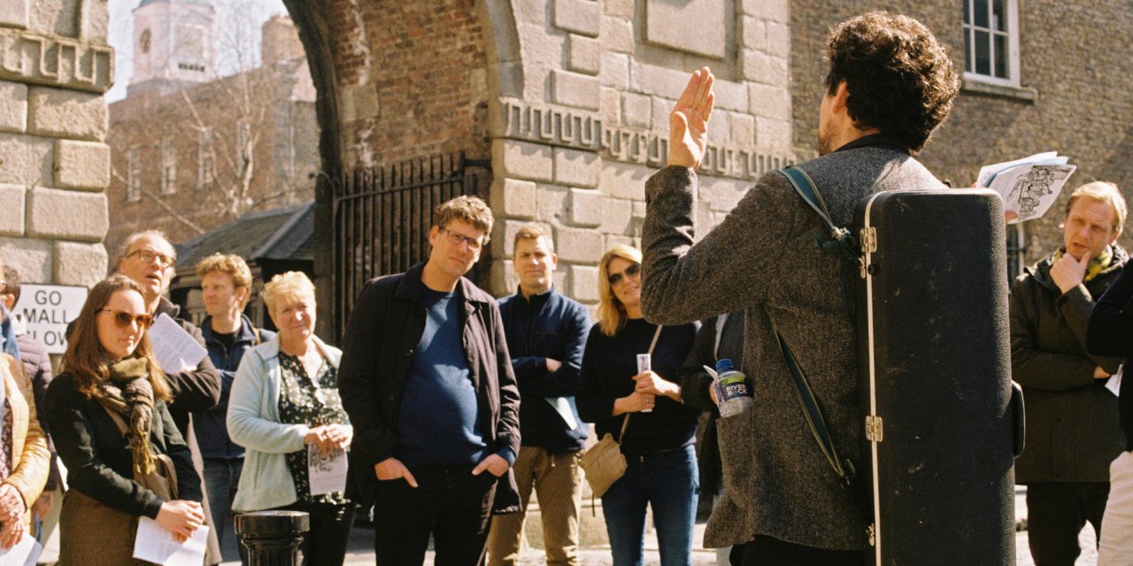 crowd listening to tour guide outside