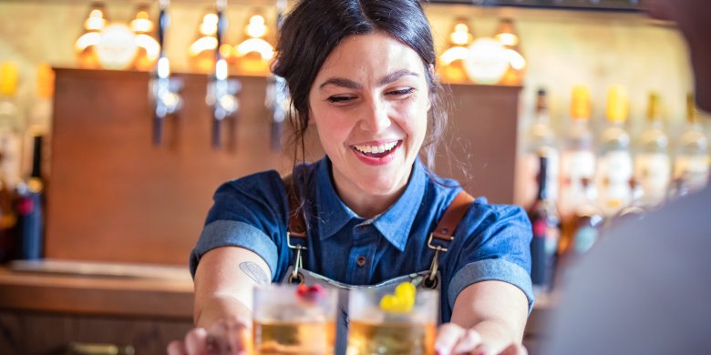 Serving drinks at Roe & Co - pic by Diageo ICP barmaid serves drinks at dublin whiskey distillery