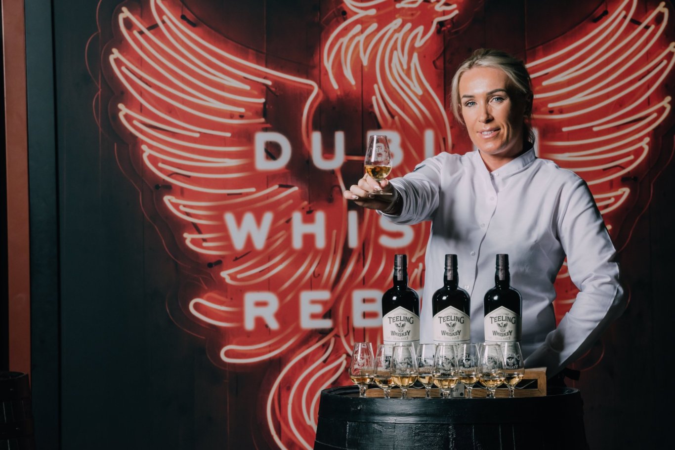 woman offering glass of whiskey 