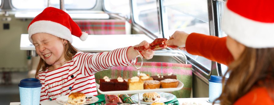 Fun on the Christmas tour - pic by Conor McCabe lady and small girl pulling cracker on vintage tea tour