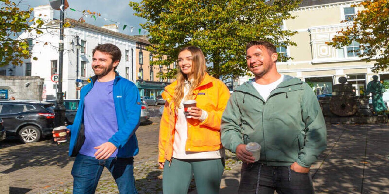 group of friend on a sunny stroll holding coffee