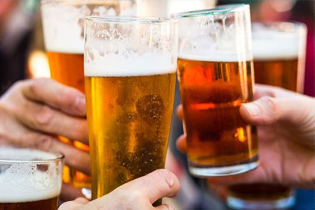 three people holding pints