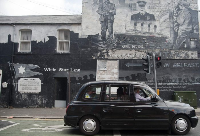 Belfast black taxi tour travelling by a wall mural