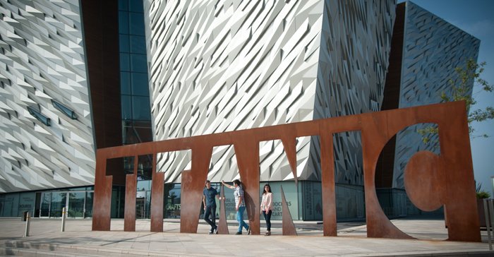Group of friends pose for photo outside Titanic Centre Belfast